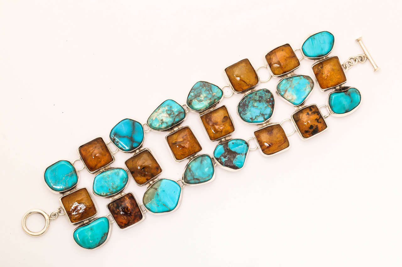 Large silver  bracelet bezel set with irregular shaped turquoise and amber . the bracelet if finished with a toggle clasp. The width of the bracelet is 2 inches and the length, with clasp, is 8 inches. This is a great Southwest style bracelet when