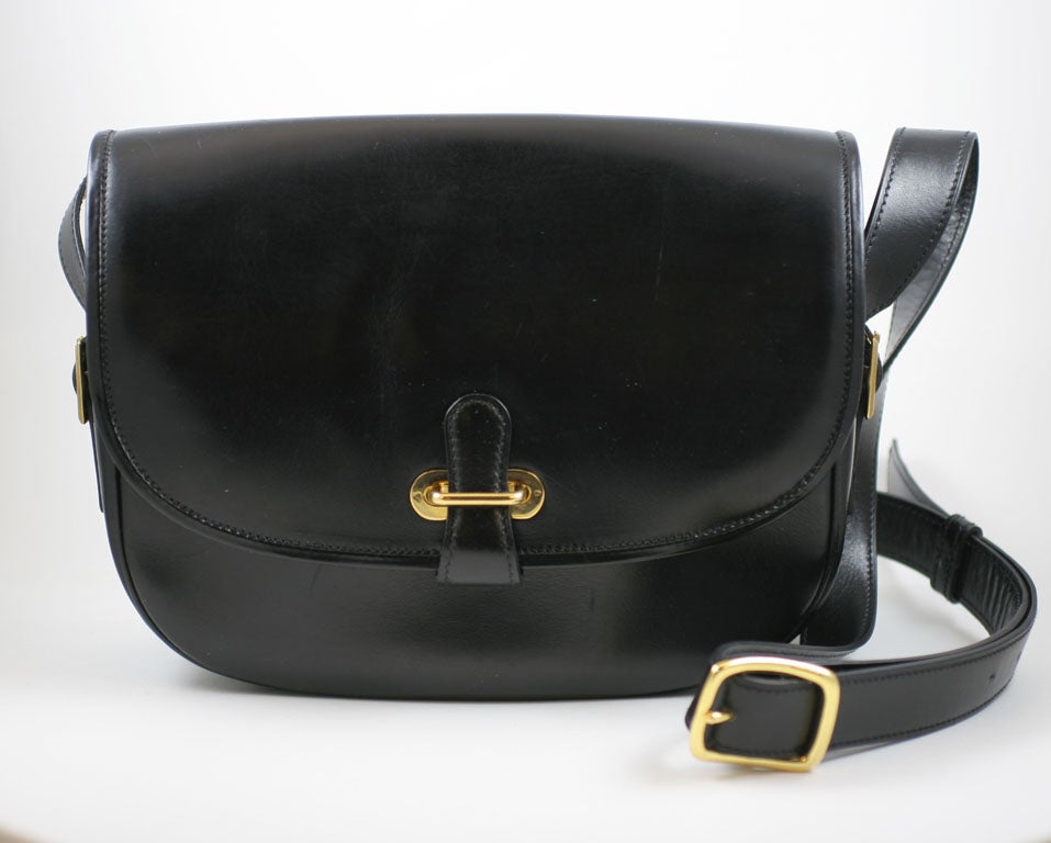 Extremely high quality navy leather saddlebag style purse made in France by J.P. Renard. Closure is by slipping a tab through a brass fitting. There is an outside pocket in the rear, an outside zipper compartment under the front flap, an additional