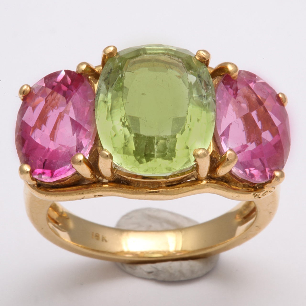Prong set Pink Topaz &.rare Tourmaline three stone band set in 18kt Yellow Gold.
Verdura style.  Tourmaline center stone & the two side stones are faceted Pink Topaz. Frilly & feminine. Ca 1980.