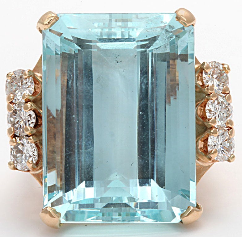 An Exceptional retro aquamarine with six diamonds set on 14 kt gold with makers mark. Intense approx 30 ct emerald cut aqua