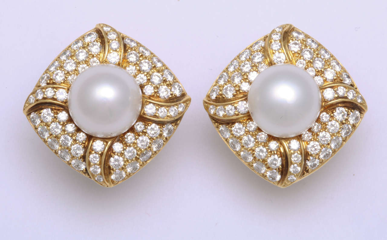 18k yellow gold earrings featuring two South Sea Pearls, 13.36 carats and 128 high quality diamonds weighing 6.80 carats.