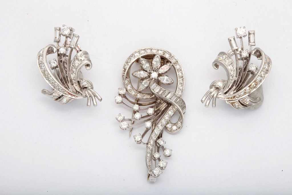 Pair of 14kt White gold Clip-on Earrings of cat tail  floral Bouquets set with round & Baguette Diamonds - accompanied by a matching Retro foliate clip, also set with round & baguette Diamonds.  Circa 1940
