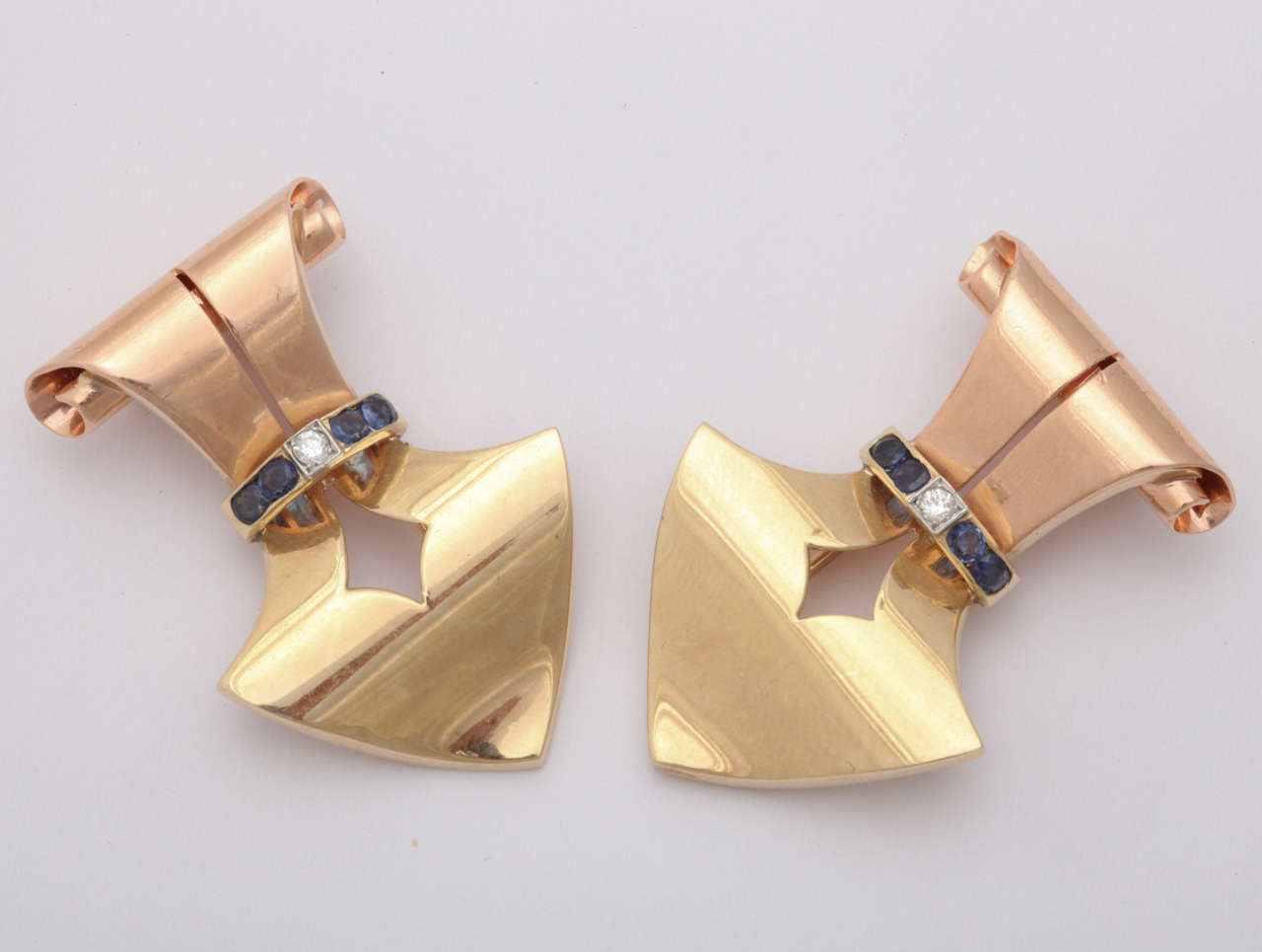 14k rose gold and yellow gold "arrowhead" shape dress clips 8 round sapphires and 2 round diamonds.

Matching design ear clips 4 round sapphire and 2 diamonds

Total weight 52.8 grams