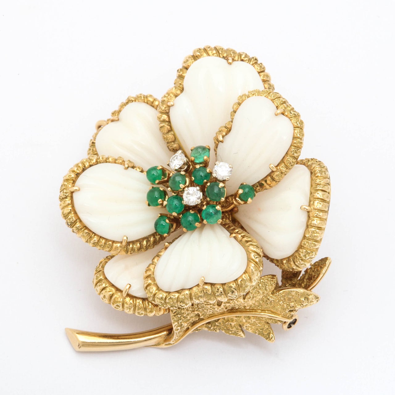 A beautiful carved white coral with Emerald and diamond brooch. This magnificent piece is in 18k yellow gold.