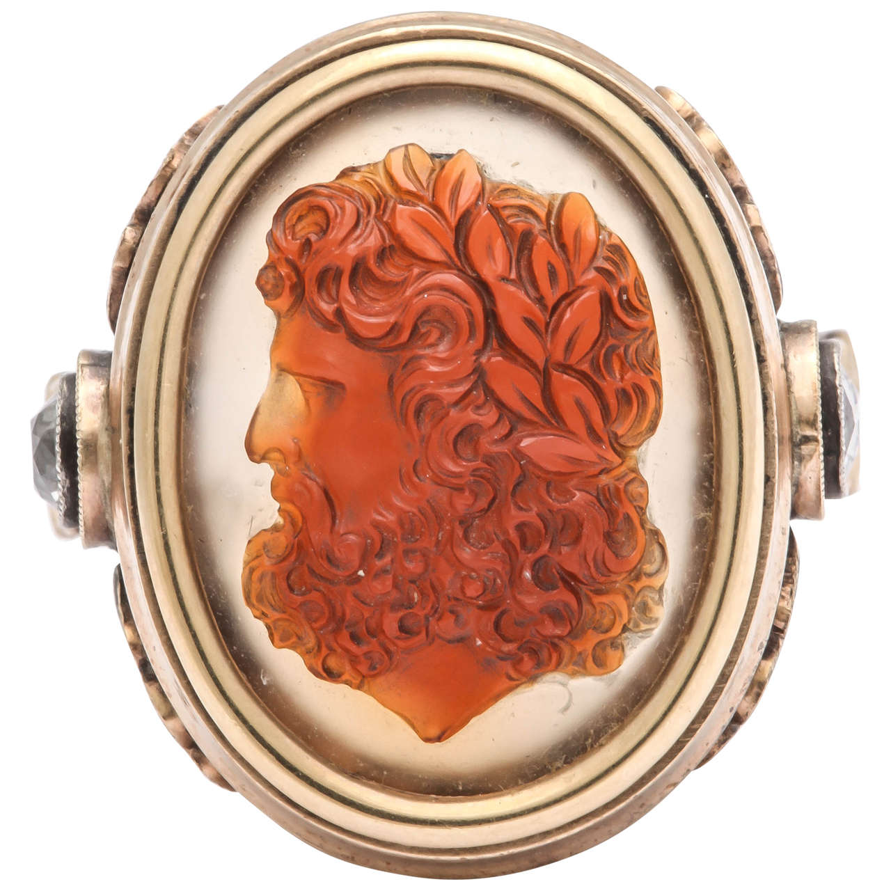 A striking oval 14k yellow gold ring set with a finely carved agate cameo depicting Zeus, god of thunder, his head entwined with polished laurel leaves. Applied on each shoulder and top of shank with three rose gold laurel leaves centering a cushion