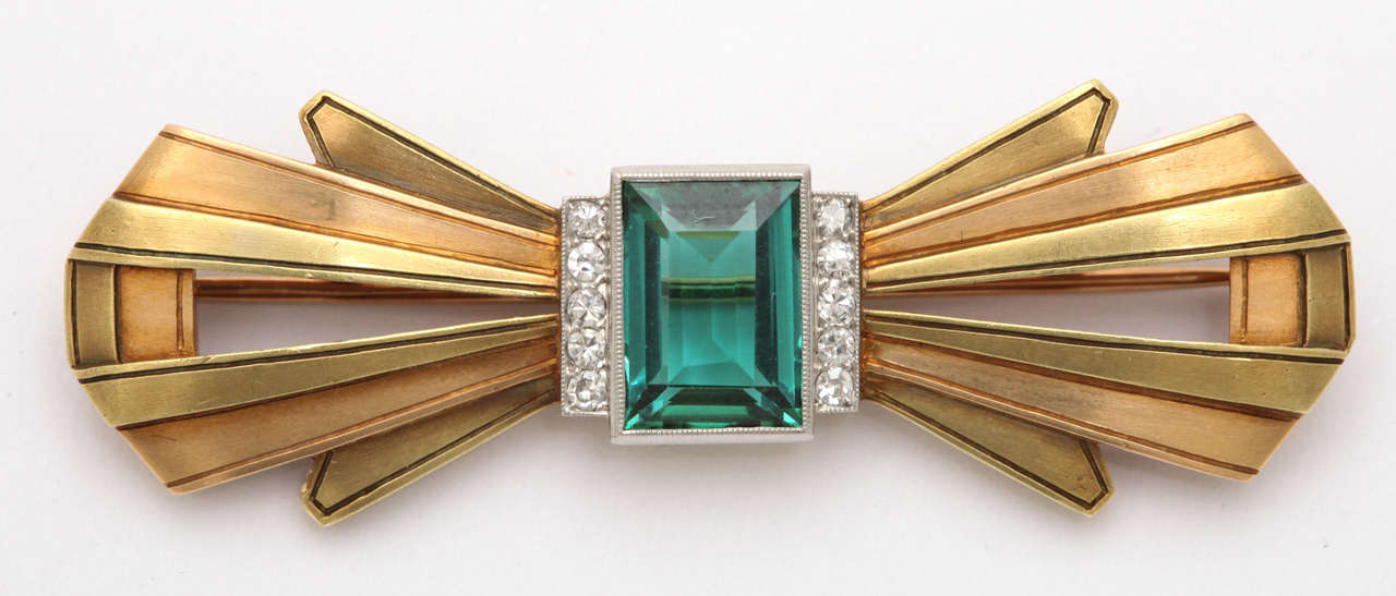 18kt Yellow , Rose Gold & Platinum Pin set with a Flawless Green Tourmaline edged with a single row of Diamonds on either side.
Beautifully constructed & created.  Ca. 1930-1940