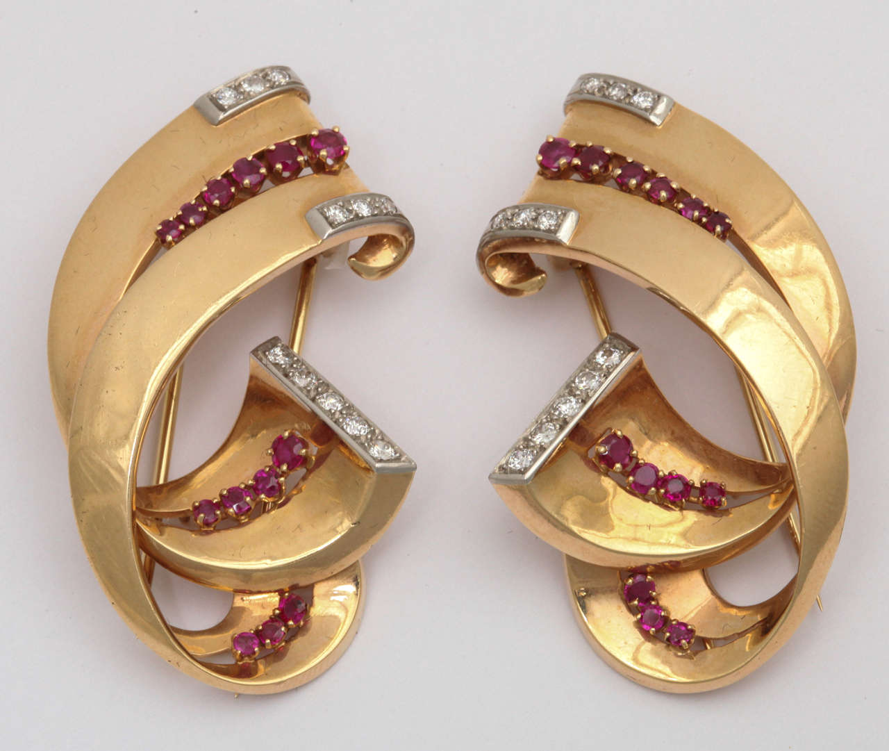 Luxurious Pair of 14Kt bejeweled Scroll Clips.  Very three dimensional and set with faceted Rubies & full cut clean white Diamonds.  Double pin backs with
hinge back closing.  Can be worn on lapels,  opposing dress cuffs.........  Just about