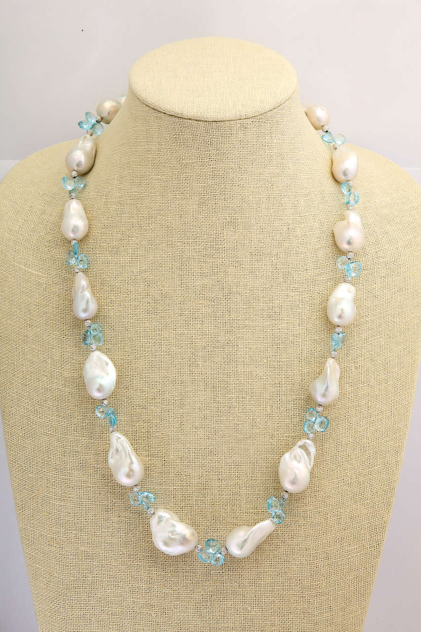Large top quality baroque pearls, largest is 1 1/4 in, smallest is 1 in., mixed with 18 kt diamond-cut white gold beads and 110 cts blue topaz briolettes. The white gold beads  and blue totaz briolettes add a wonderful sparkle and play of light that