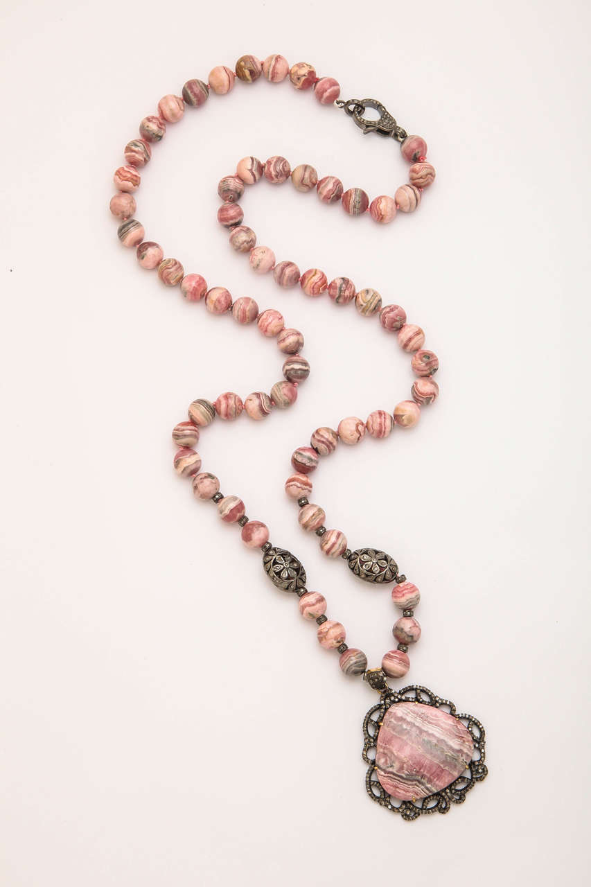 This beautiful necklace is the rich rose color of rhodochrosite with sedimentary stripes of lighter pink, whit, and grey. It is  mostly mined in Argentina and is Argentina's national gemstone. Also it is the state mineral of Colorado since 2002. The