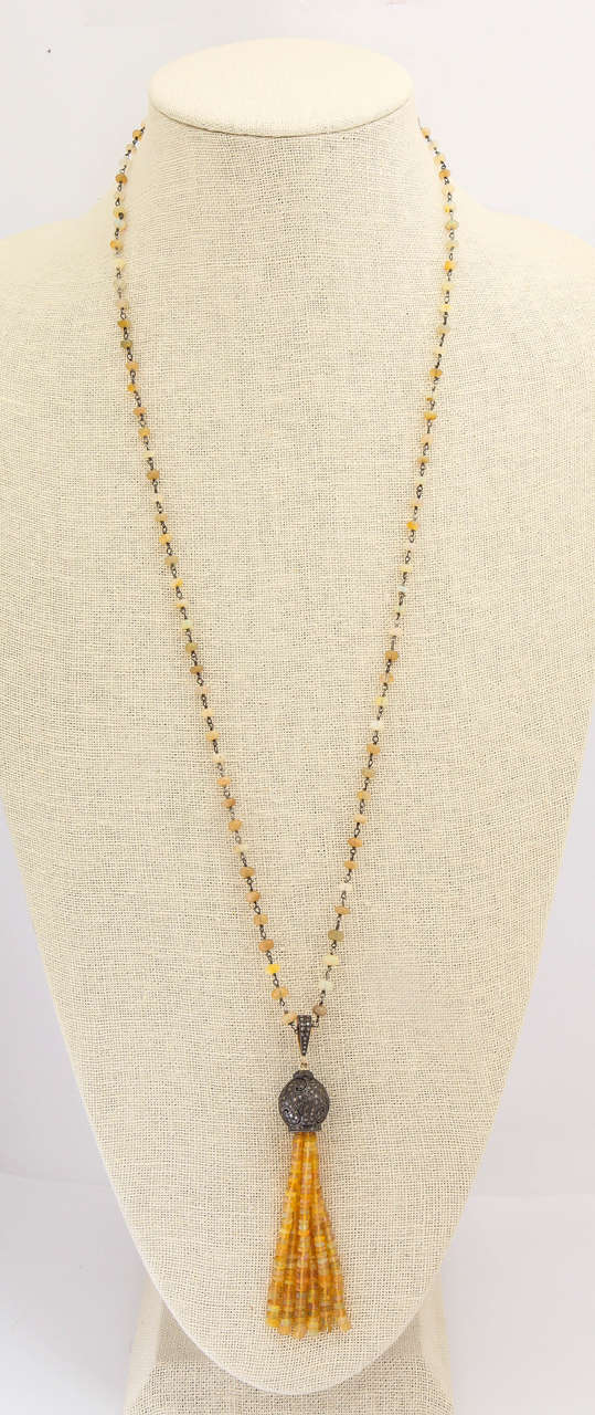 A stunning 3 3/4 inch multistrand tassle of 30.5 ct  beautiful Ethiopian opal beads, silver and 2.4 ct diamonds is suspended from a 36 inch silver and opal bead chain. Charming and unusual, this necklace reminds one of exotic far away places with