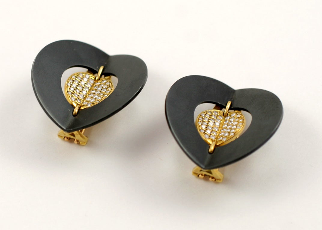 Der italienische Designer Gio Caroli ist für seine ungewöhnlichen Schmuckentwürfe aus den 1960er und 1970er Jahren bekannt.  Eine biegsame, mit Diamanten besetzte Goldscheibe wird von einer größeren, gebogenen, oxidierten Metallscheibe umschlossen.