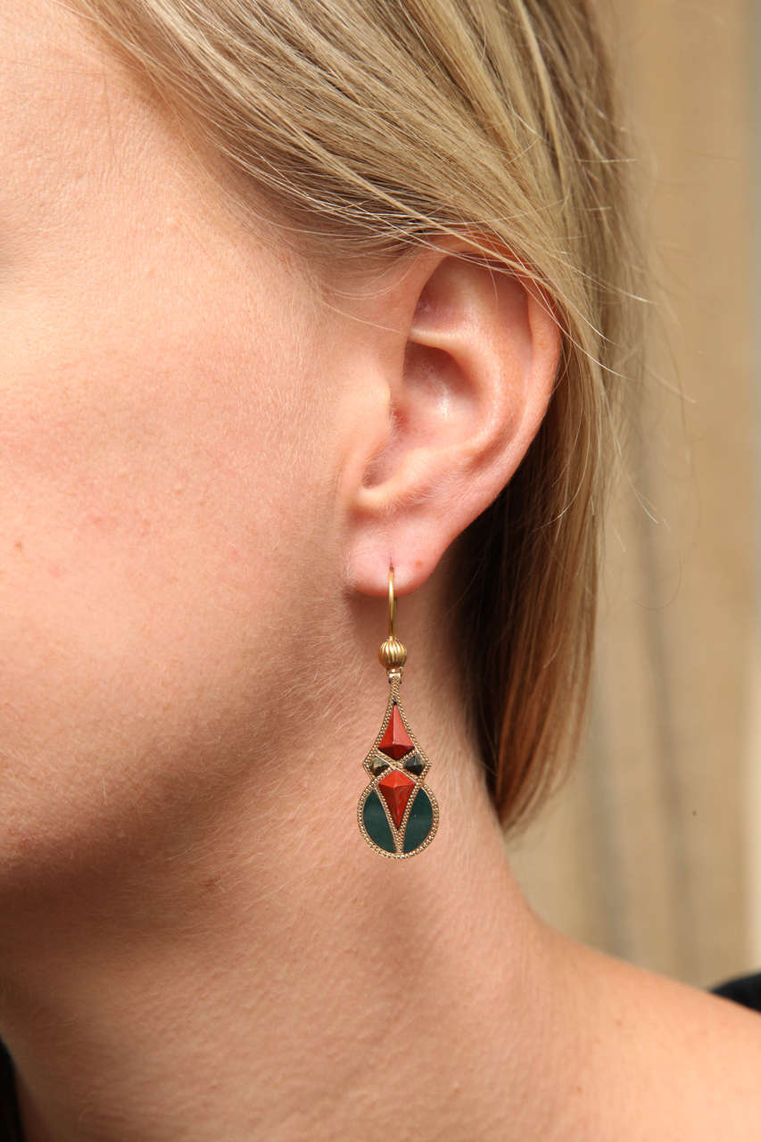 Although Victorian, this pair of original  Scottish agate earrings are so modern in design that they resemble the geometry of the Art Deco Period. An elongated diamond form in raised carnelian and moss agate collides with a circle of forrest green