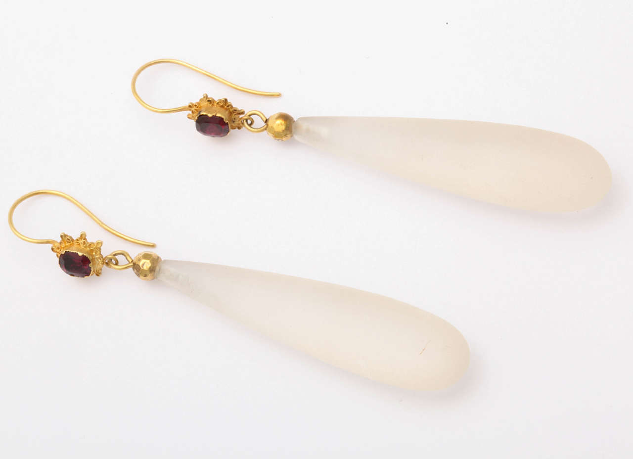 Mesmerizing, seductive, elegant, Victorian earrings in an extended teardrop of pure chalcedony. On top, at the ear, a cushion cut garnet set into a gold star, adds an artful touch of color. We adore earrings such as these for their simple beauty and