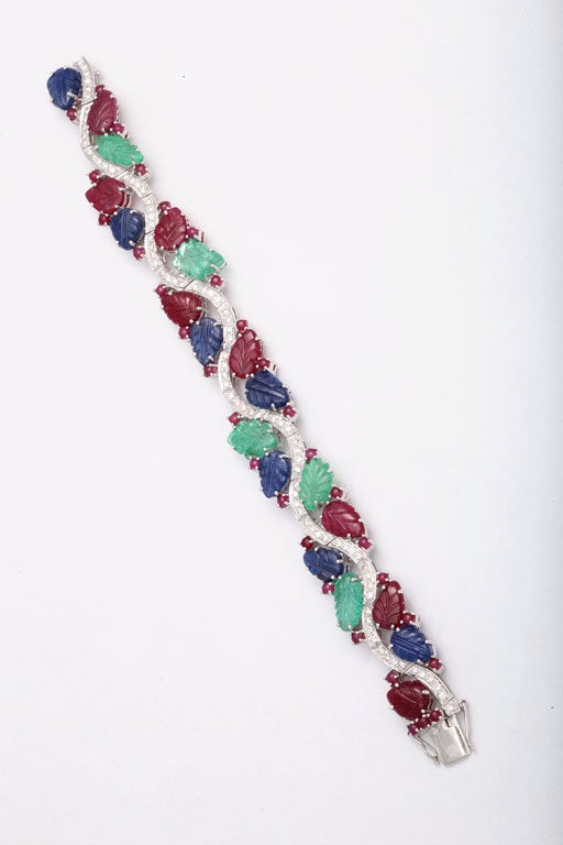 

The set features sapphires, emeralds, and  rubies carved to resemble leaves.  The leaves are set along a diamond swirl.  The diamond weight is 1.89 carats.

The bracelet measures 7