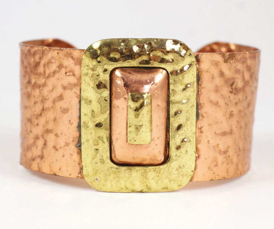 Wide copper cuff with large decorative buckle.