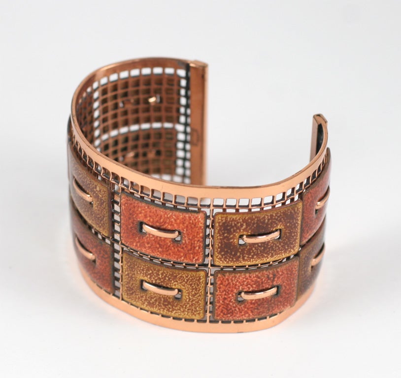 Copper grid cuff with rectangular copper and enamel pieces attached to grid.