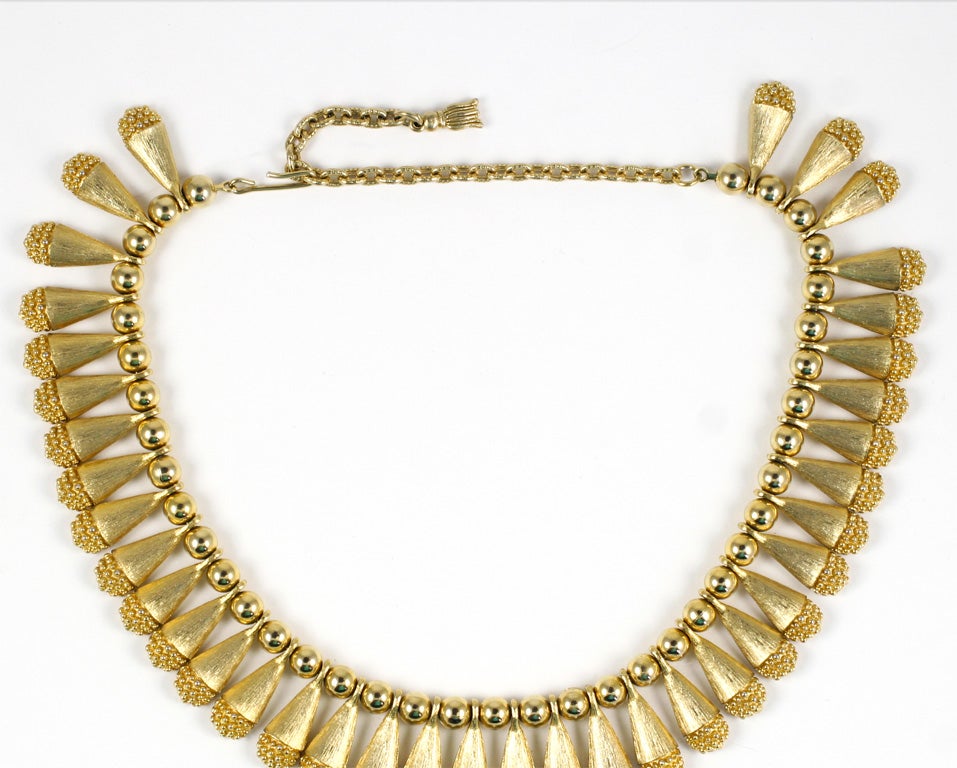 Goldtone bead and textured teardrop collar style necklace.