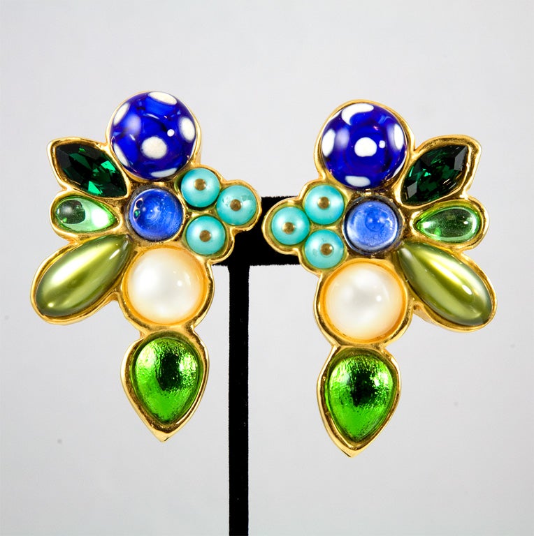Here is a pair of rare and stunning runway earrings by the House of Chanel.  Wonderful 80's oversized scale, gold plated resin set with an assortment of colored stones in blues and greens.