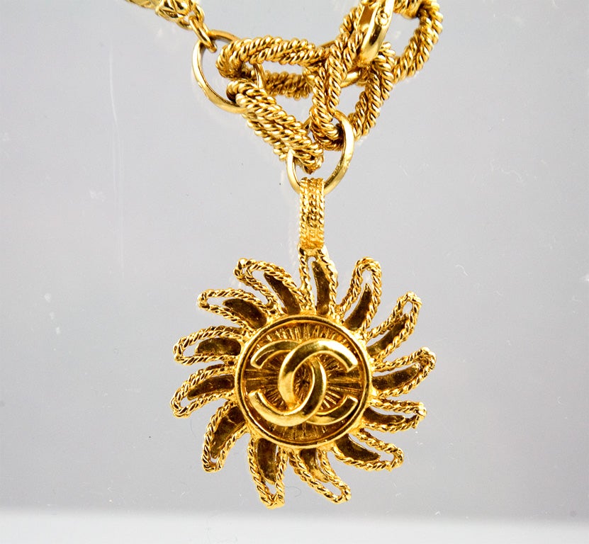 A stunning double strand rope chain necklace featuring a beautiful sunburst pendant with interlocking 