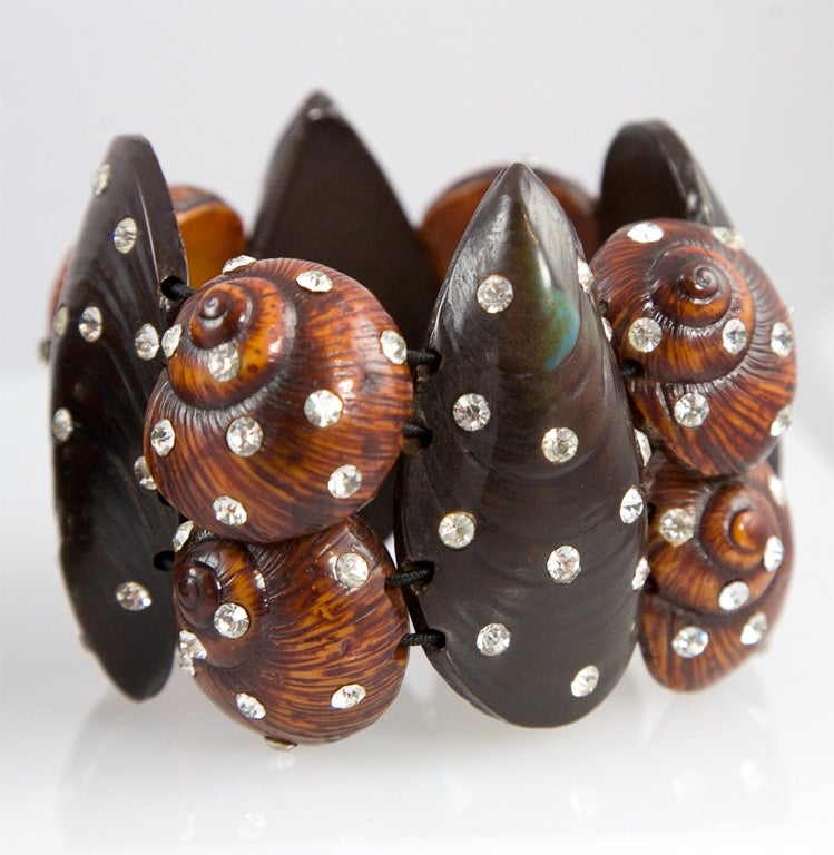 Featured are two molded resin sea shell bracelets encrusted with clear rhinestones and strung on elastic banding. These bracelets were designed by Karl Lagerfeld for Fendi and worn on the runway.  The price given is for the pair of bracelets, but