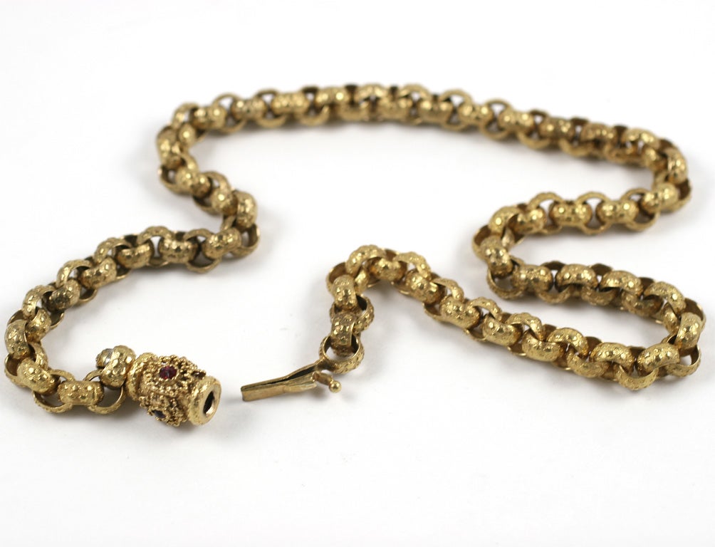 The charm of links that are made by hand comes to us from the early 19th century in the form of a pinchbeck chain sporting its original barrel clasp. Rows of little stars encircle each round link. Behind them the heavens are tinier dots that cover