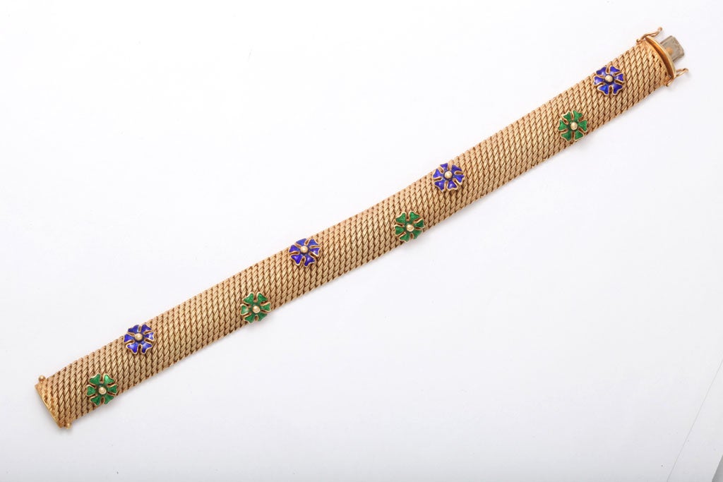 bracelet 1/2 rond avec florettes à six pétales en émail appliqué et perle centrale en or.