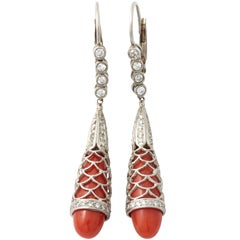 A pair of platinum diamond and coral pendant earrings