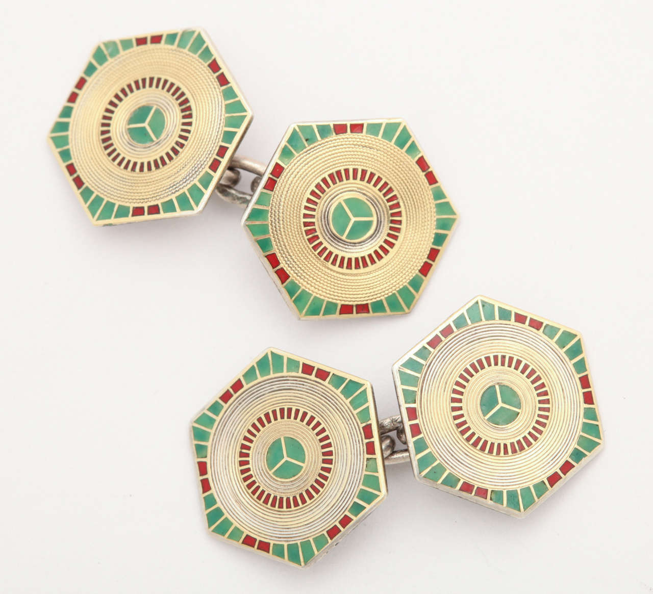 Stunning enamel coloration of gold, green and red make geometry speak in this pair of sterling silver, gold and  enamel cufflinks c. 1920-30. The links, double sided hexagons, show outstanding design.  The center circle of green is surrounded by