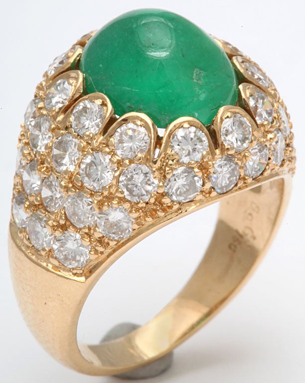 Ultra chic Cabochon Emerald ring set in 18kt. Yellow Gold mounting.   Scalloped circlet  of very clean, full cut super white Diamonds.  Second row another circlet od Diamonds with another two rows of Diamonds completing the shoulders of the