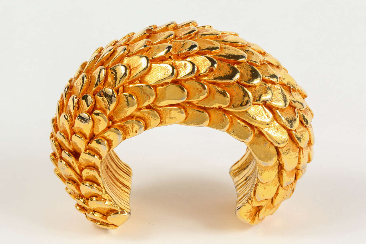 A striking gilt resin cuff, by Dominique Aurientis, with a feather motif. Marked on the inside of the cuff with the round 