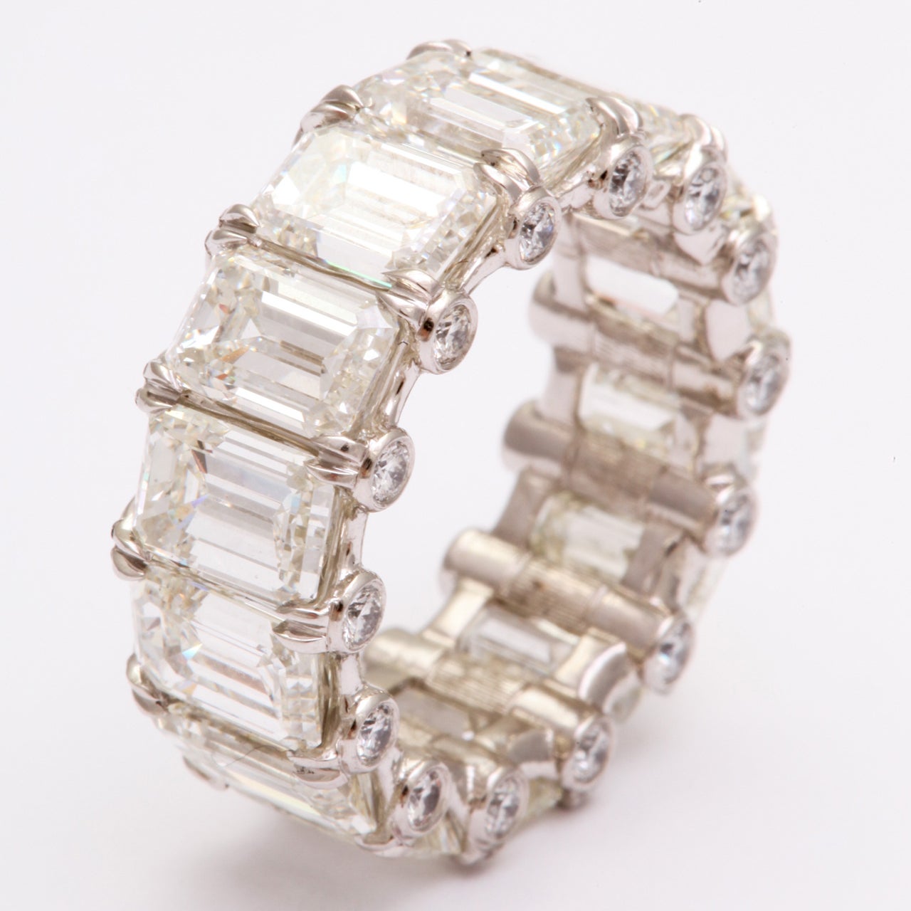 Matched beautifully, this platinum emerald cut diamond band features 14 diamonds weighing 12.86 carats, flanked with 28 round diamonds weighing 0.68 carats. A real show stopper!!!