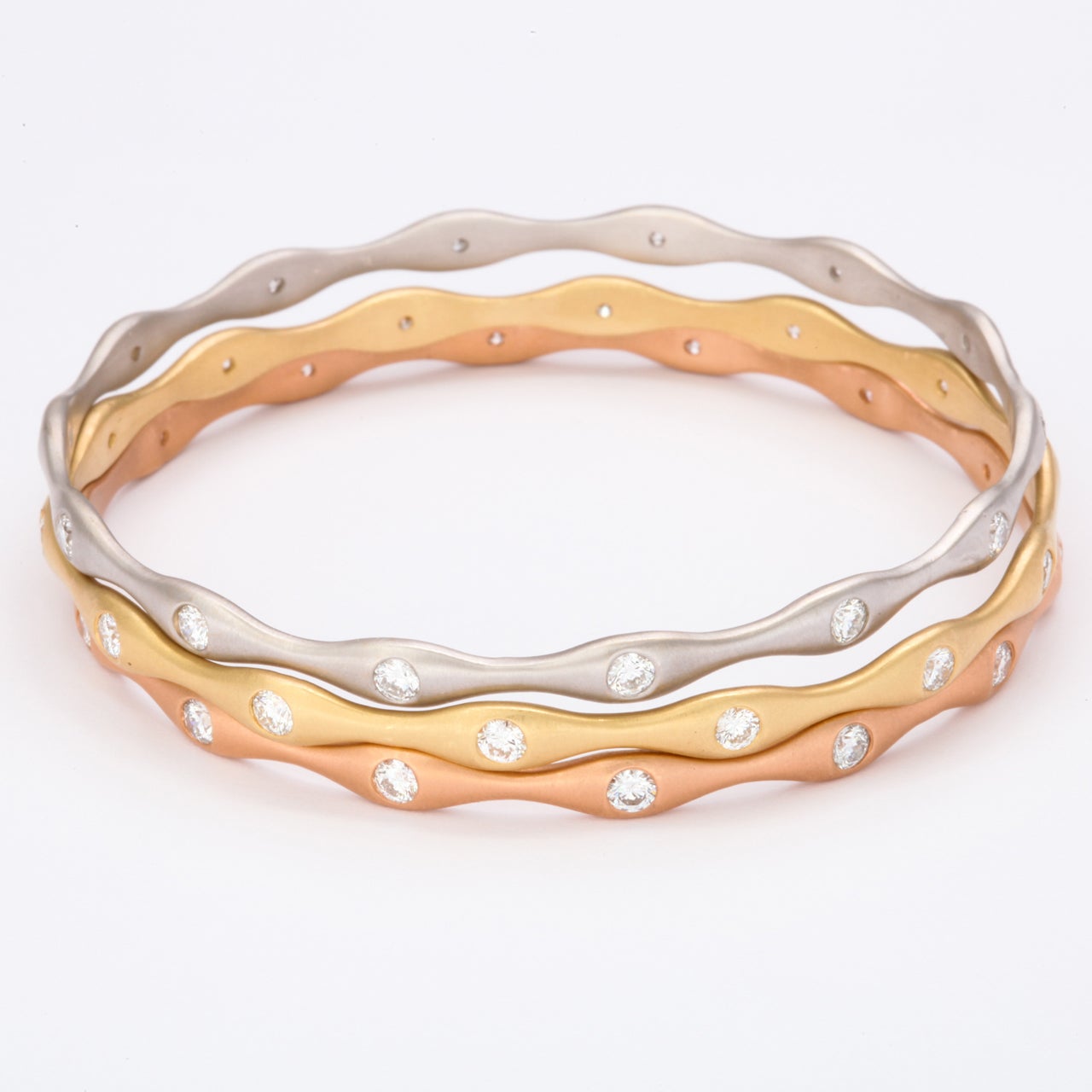 Gorgeous set of 18k white, yellow and rose gold bangles. Each bangle features 14 round diamonds. 
Rose-1.46 Carats
White-1.39 Carats
Yellow-1.48 Carats

Can be sold separately.