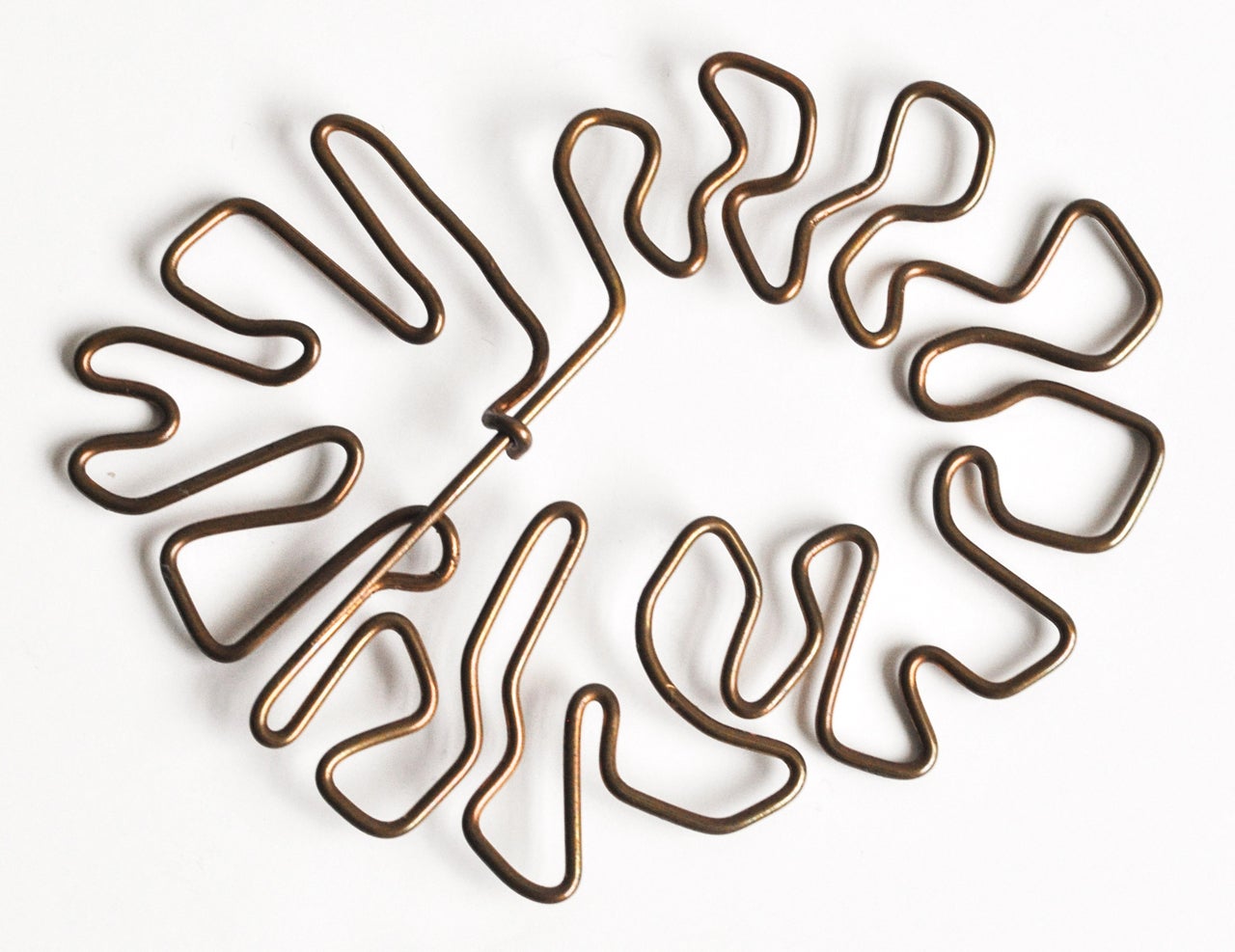 A large abstract brooch by Val Bertoia (b.1949). Free-form bronze wire with etched number documenting this work.  An innovative, organic design with an integrated clasp.

Included is a title of authentication by Val Bertoia