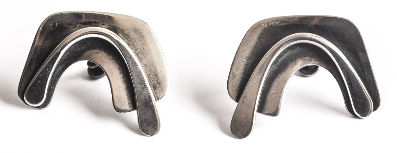 A pair of hand-wrought sterling silver earrings with original patina by the New York  jeweler Art Smith (1917-1982). Smith, who opened his first shop in Greenwich Village in 1946, was one of the leading proponents of post-War modernist jewelry in