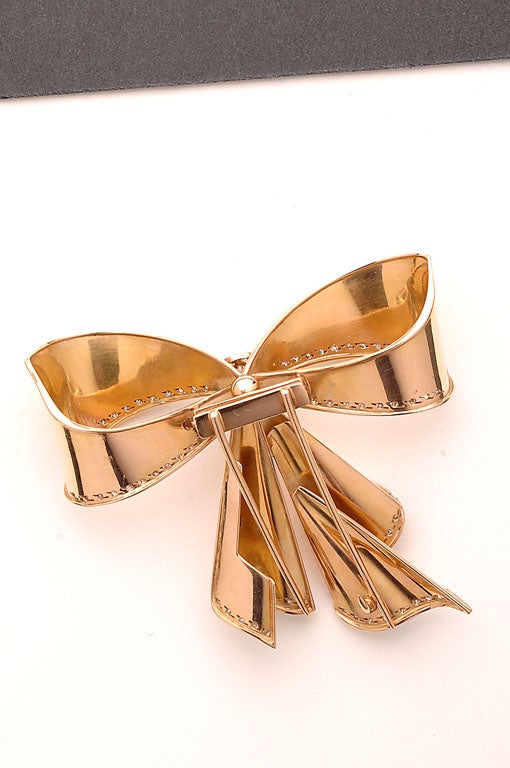 Retro fourteen karat gold bow pin with diamonds. Gold beautifully formed to give the effect of draped fabric.