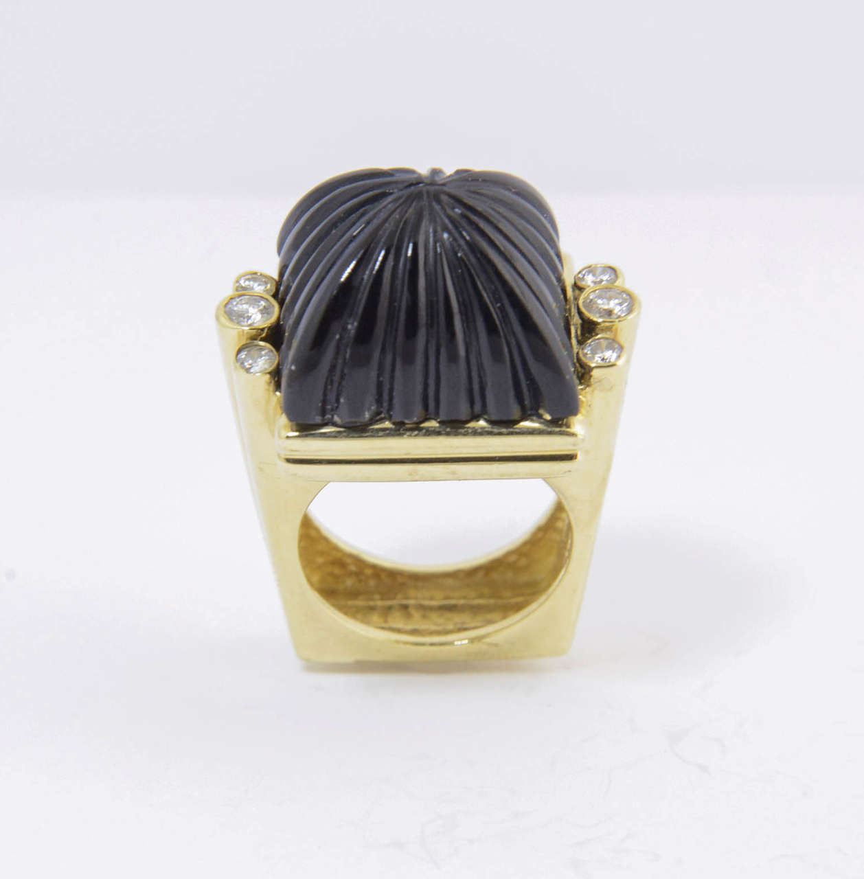 The design of this ring is great.  It is 18k yellow gold with a carved onyx dome center with 3 diamonds on either side.

US size 6.5