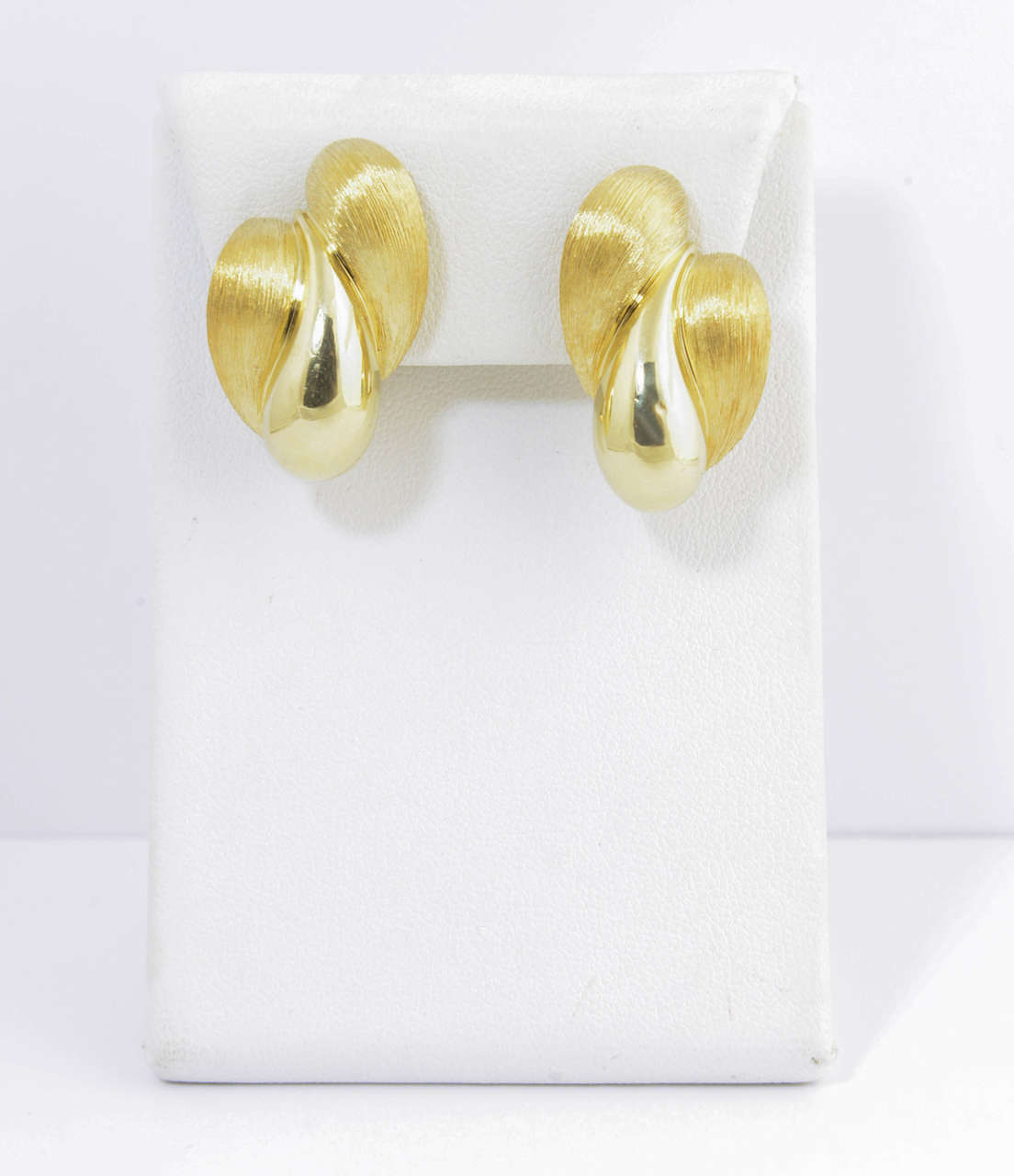 Designed by Henry Dunay, these earrings feature a high polish and Florentine finish yellow gold curl seductively up the ear.  These earrings have omega backs (no posts).