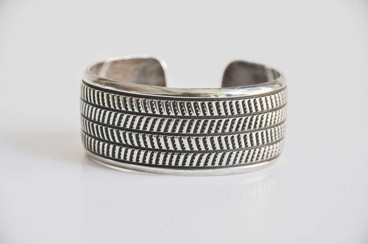 A hand-wrought sterling silver cuff with an interesting geometric band design.
Artist signed.