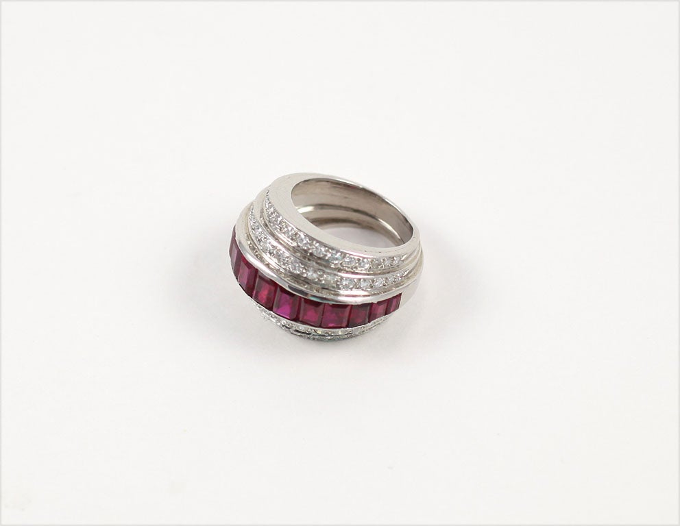 A fabulously fancy Deco ring. A row of calibre-cut rubies is centered between two stepped-rows of pave diamonds. Ring size 5.5