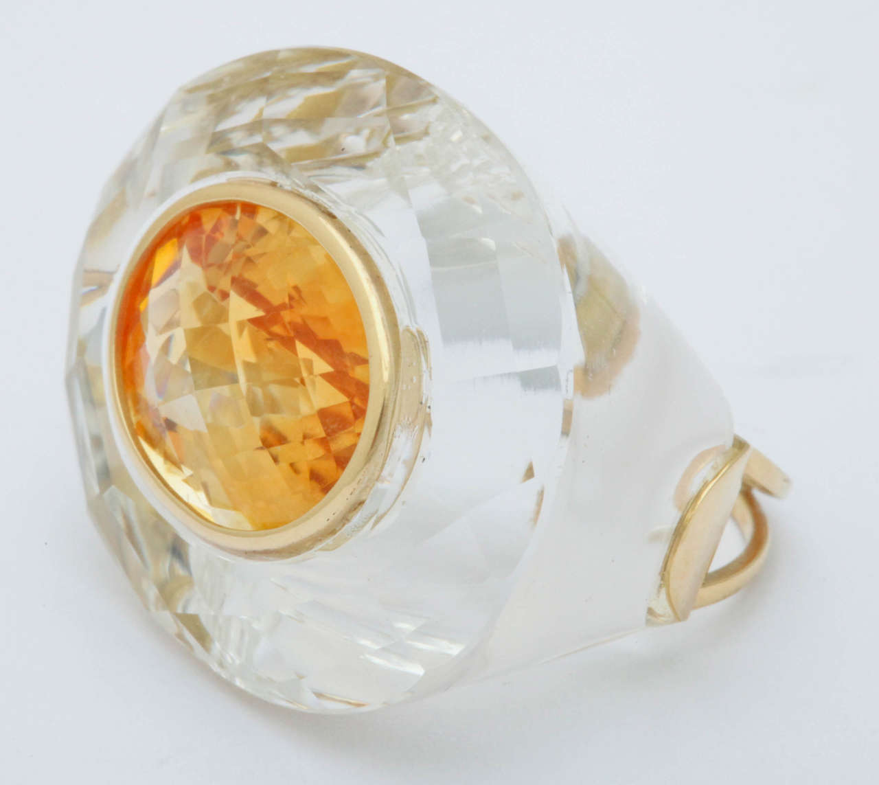 This unique ring has a 1/2 in. by 3/4 in. bezel set citrine surrounded by a carved and faceted rock crystal. The citrine is deeply cut,  which enhances the rich golden color.  The top of the citrine is a checkerboard cut to enhance the brilliance.