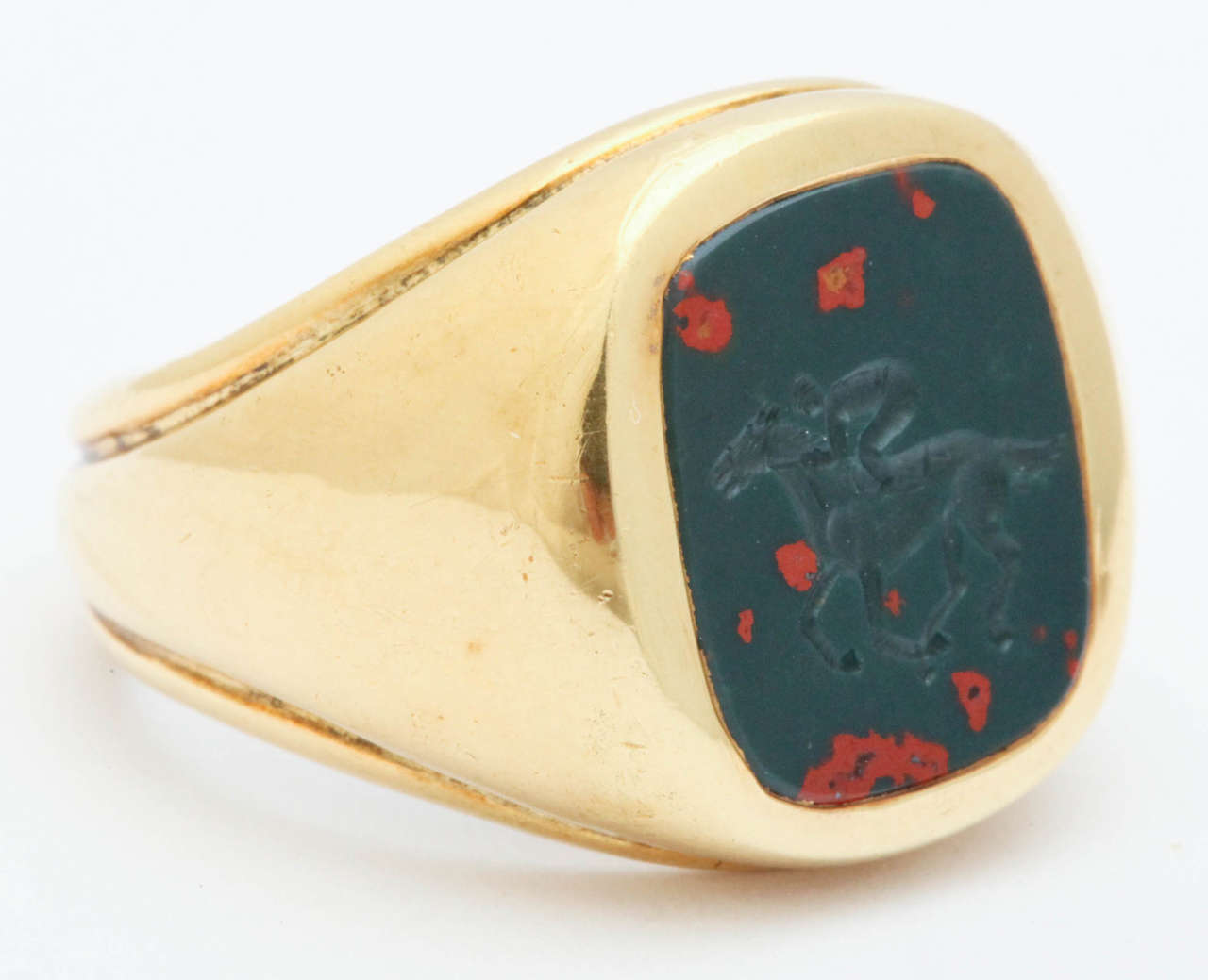 18K Bloodstone Intaglio Ring Depicting the King of Sports, Thoroughbred Racing. Bloodstone  is a Green Jasper Dotted with Bright Red Spots of Iron Oxide. 

The present ring size is  7 1/2.  It is a unisex ring and can be made in any size.