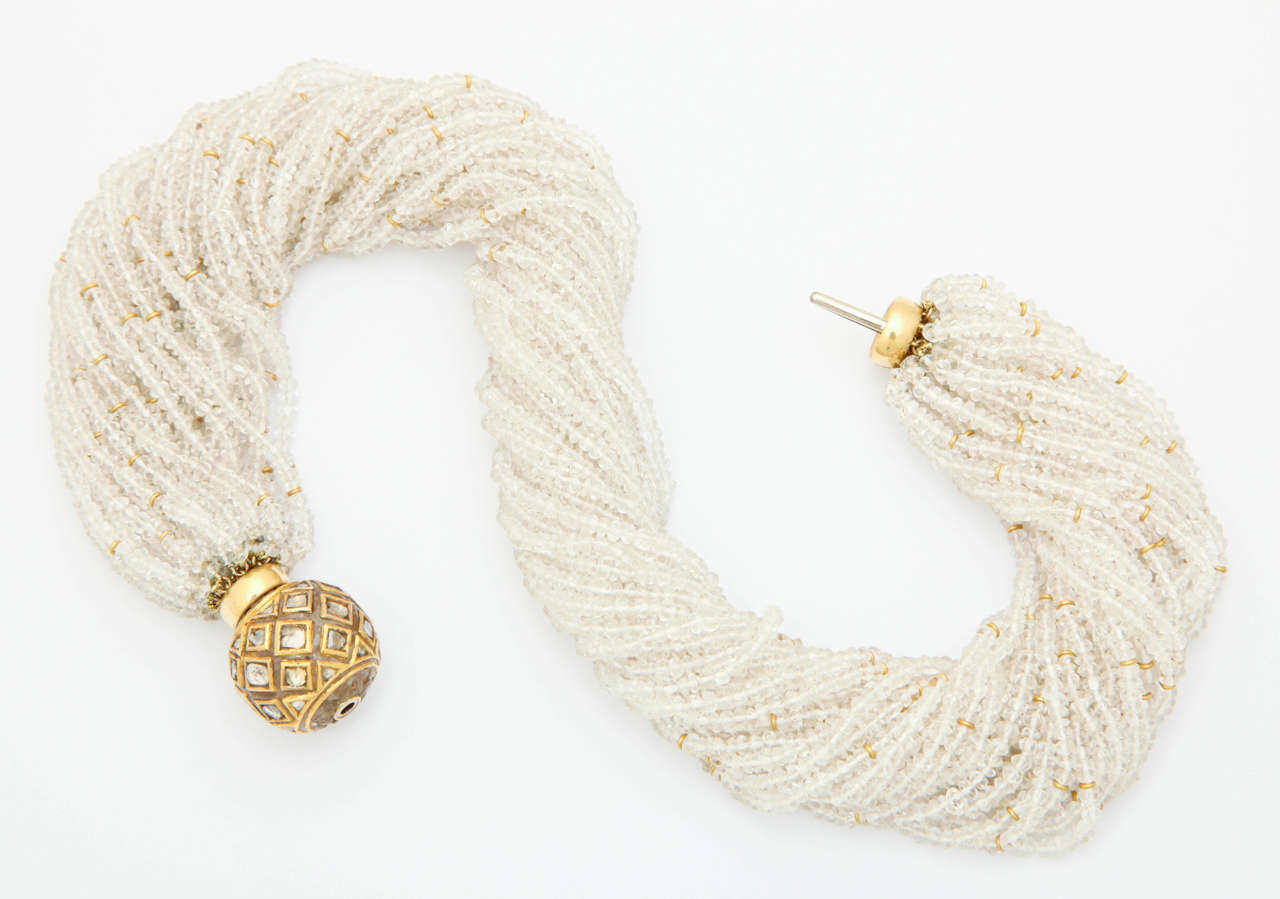 This 1 in. carved crystal ball, inlaid with diamond polki set in 24 k gold, has been made into a clasp for 32 strands of crystal beads interspersed with many 18k rondelles. This elegant necklace is a neutral color to match all of your wonderful