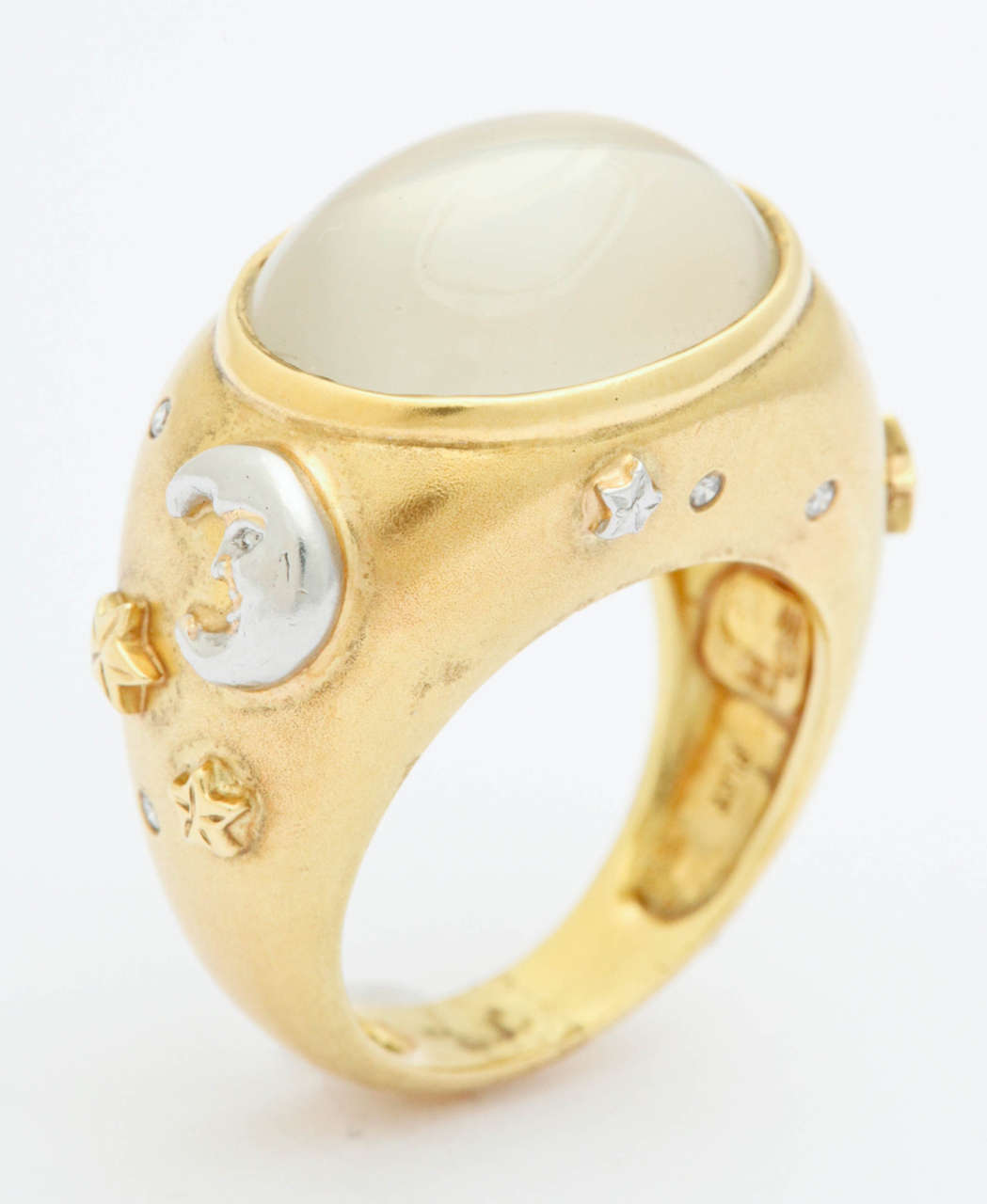Off to another galaxy with this 18K and platinum ring. The center moonstone is 9.5 cts and approximately 1/2 in. by 3/4 in.

A platinum happy faced star and crescent moon are on either side of the moonstone along with engraved gold stars and a