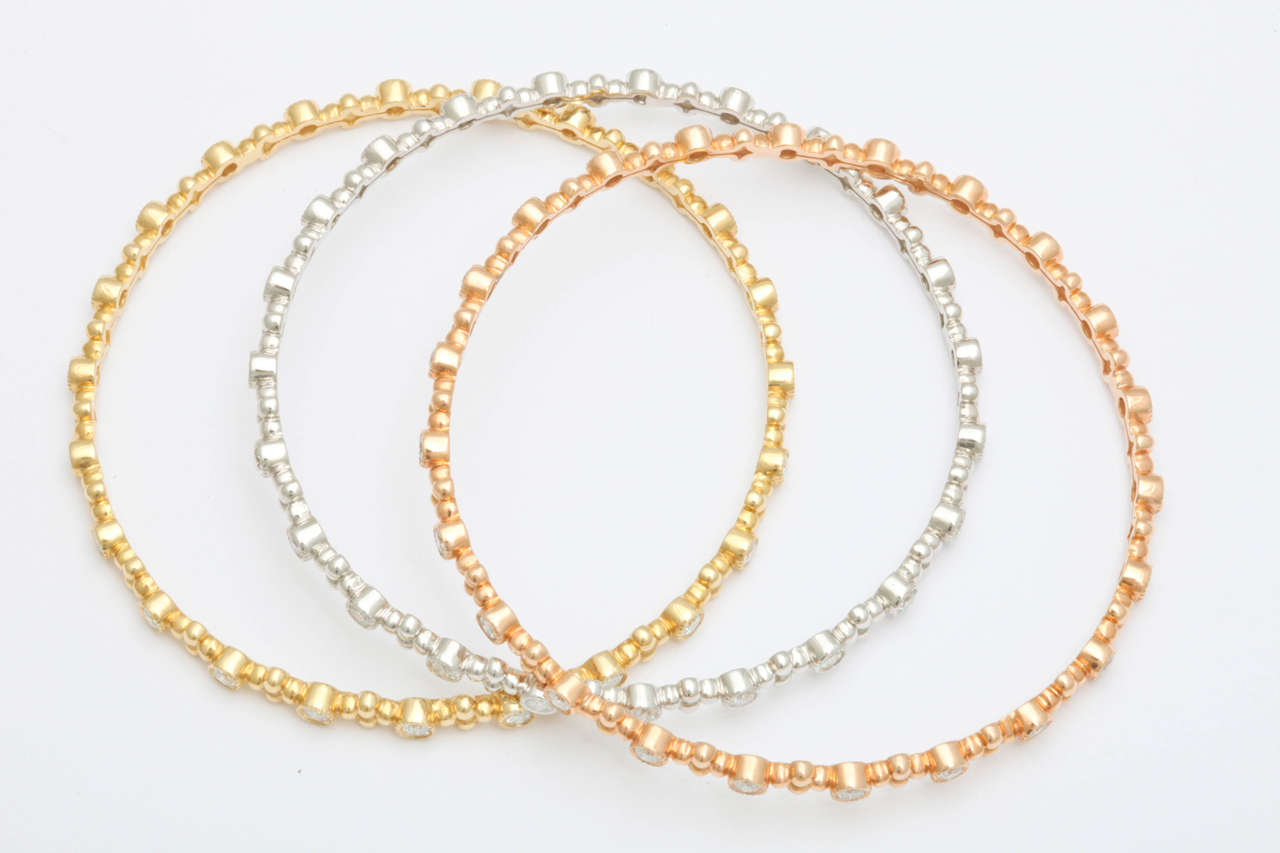 A set of 18k yellow, white, and rose gold bangles featuring 69 round brilliant cut diamonds weighing 4.31 carats.

Can be sold separately.