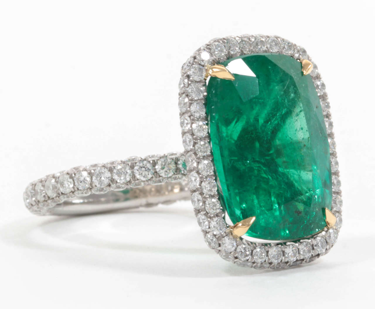 A beautiful green emerald set in a fashionable and wearable everyday (into night) setting. 

9.10 carat cushion cut 100% natural oiled Emerald.

Over 2 carats of round brilliant cut diamonds set in a custom, handmade platinum micro pave halo