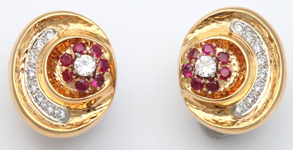 Beautifully made hand hammered ruby and diamond flower design shell earrings with superior quality diamonds and set with 16 burmese faceted rubies and with numerous diamonds weighing approximateley 2 carats set in platinum Andrew clunn is the lead