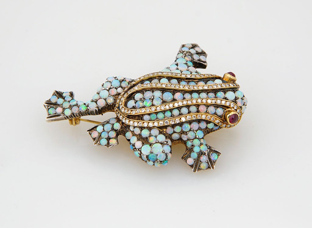 Adorable frog brooch features over 4 carats of opals with diamond accents and ruby eyes. The piece is 18k yellow gold.