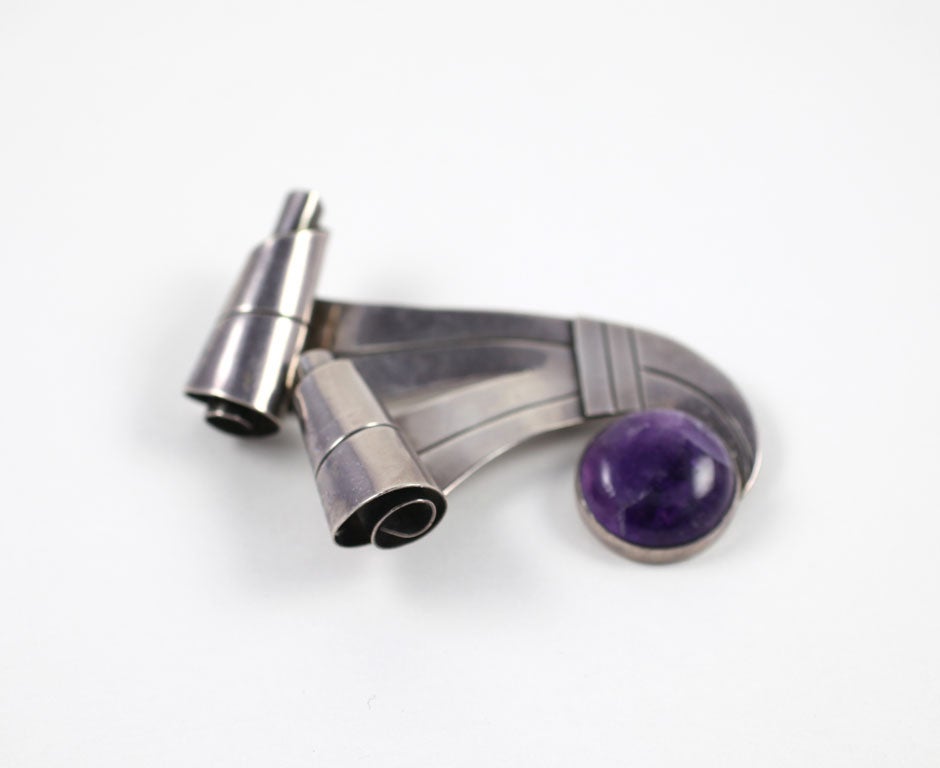 The sinuous silver curves and scrolls of this large brooch boomerang into a sphere of amethyst quartz in a well known Spratling form from his original studio in Taxco.  The large brooch can be worn as you choose, horizontally or vertically, even