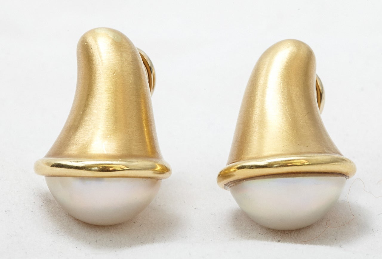 A pair of attractive 18k golden earclips set with a pair of mabé pearls. The back of the earrings are finished off with matt design, signed CUMMINGS 1989. 
Angela Cummings is a renowned jewellery designer who also designed for Tiffany & Co NY for