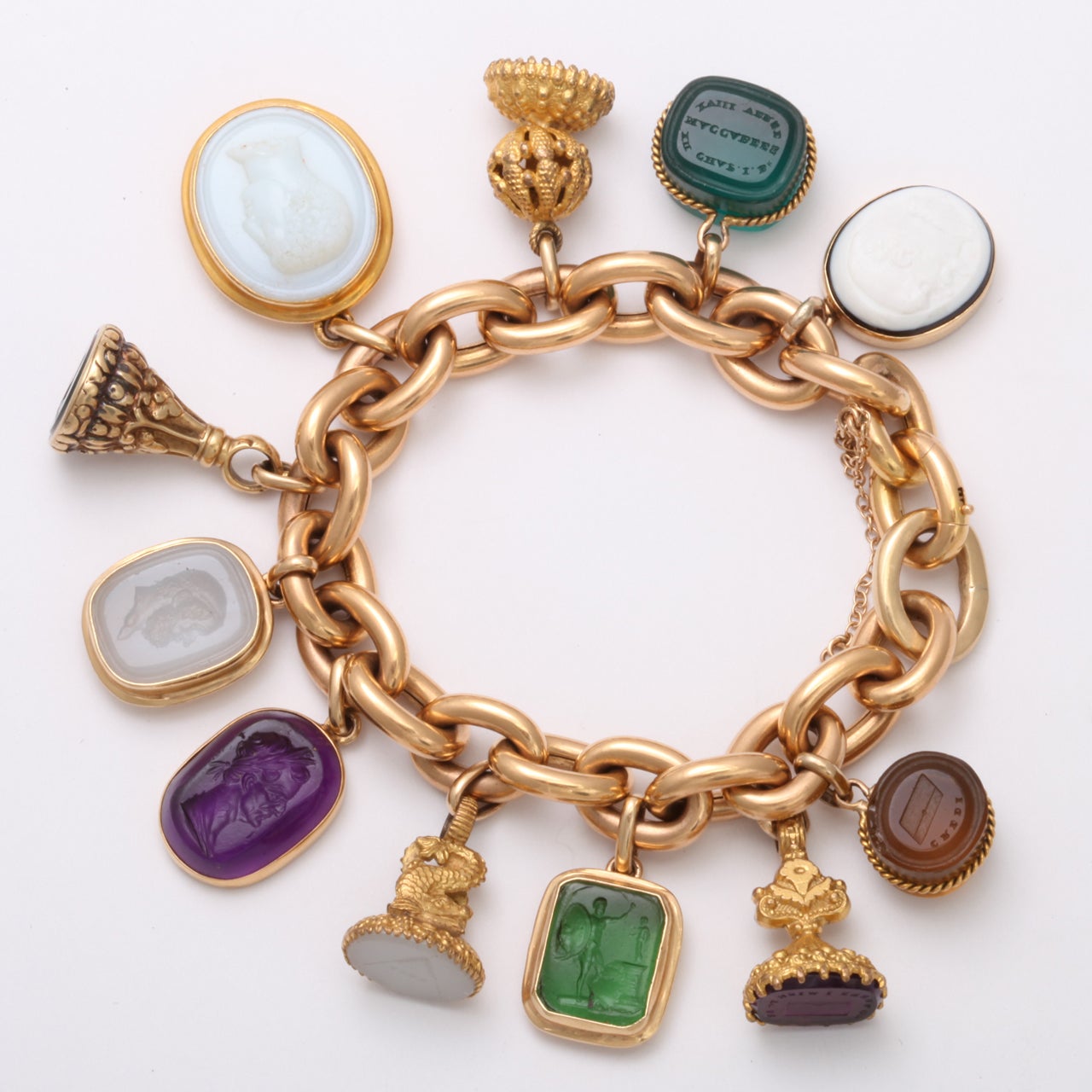 Color galore, white purple green, amber, gold and multiple stones including amethyst, banded agate and chalcedony and glass intaglios fill this 1940's 18kt French Bracelet. 
The intaglios are engraved figures and messages and fantastic portraits